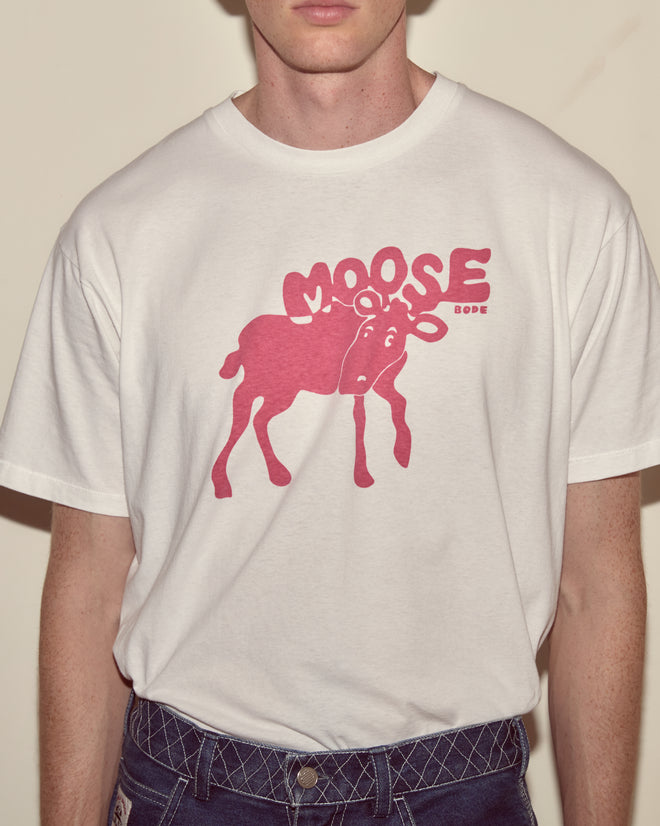 Someone wearing the Antlers Tee—a midweight cotton T-shirt featuring a bold red moose graphic and the word 