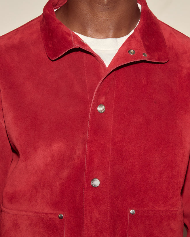 Close-up of a person wearing the Welding Jacket - Red, crafted from premium cow suede over a white shirt, highlighting its snap buttons and collar.