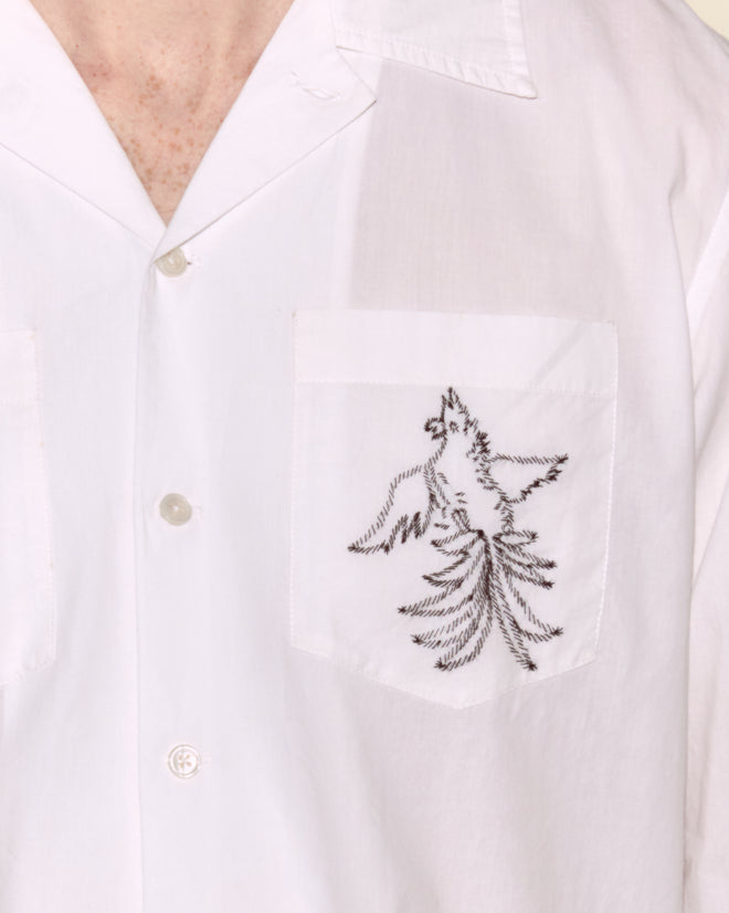 Close-up of the Cockatoo Long Sleeve Shirt, showcasing a cotton silk blend with a black cockatoo embroidered on the chest pocket featuring intricate handmade details.