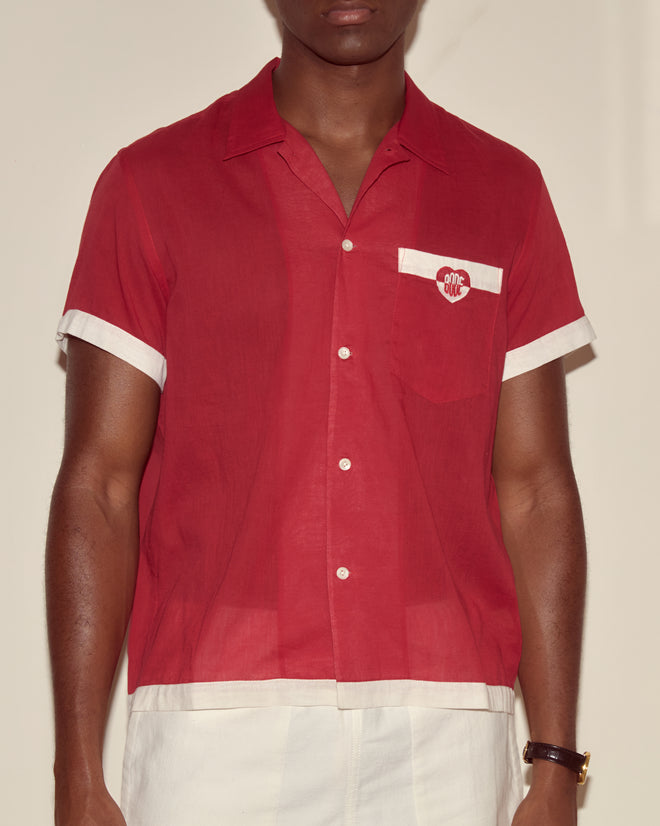 A person wearing the Heart Deco Short Sleeve Shirt in red/white paired with white pants.