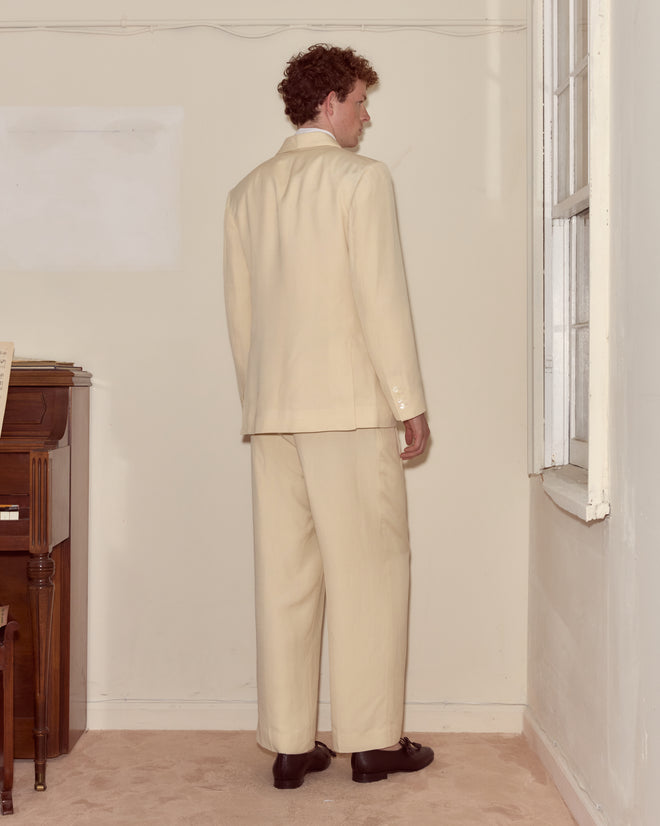 A man wears the Slub Weave Tuxedo Jacket, featuring a refined shawl collar and crafted from a breathable viscose-linen blend.