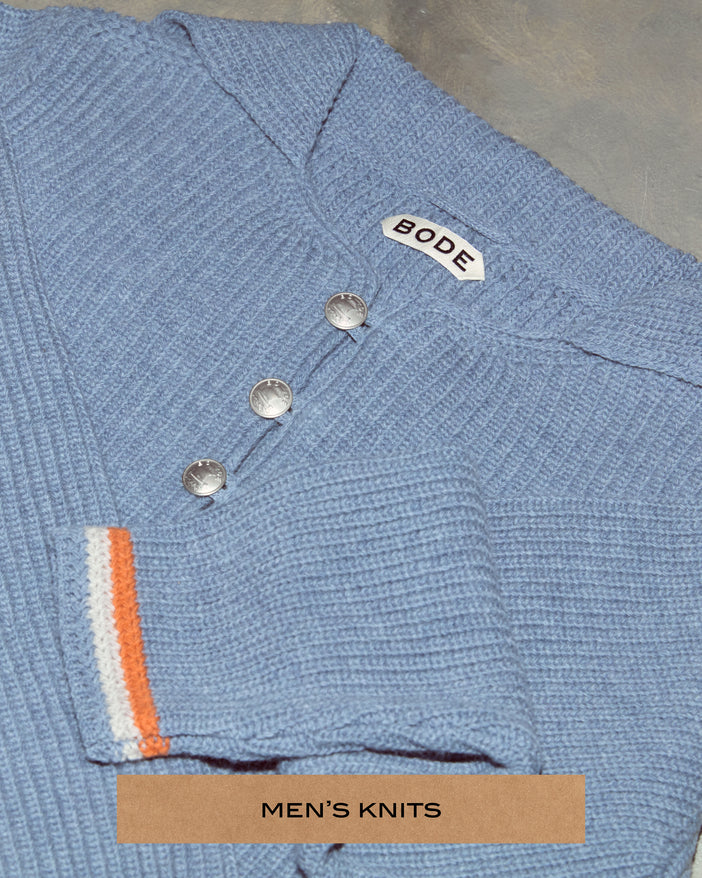 Close up of a blue sweater with silver buttons.