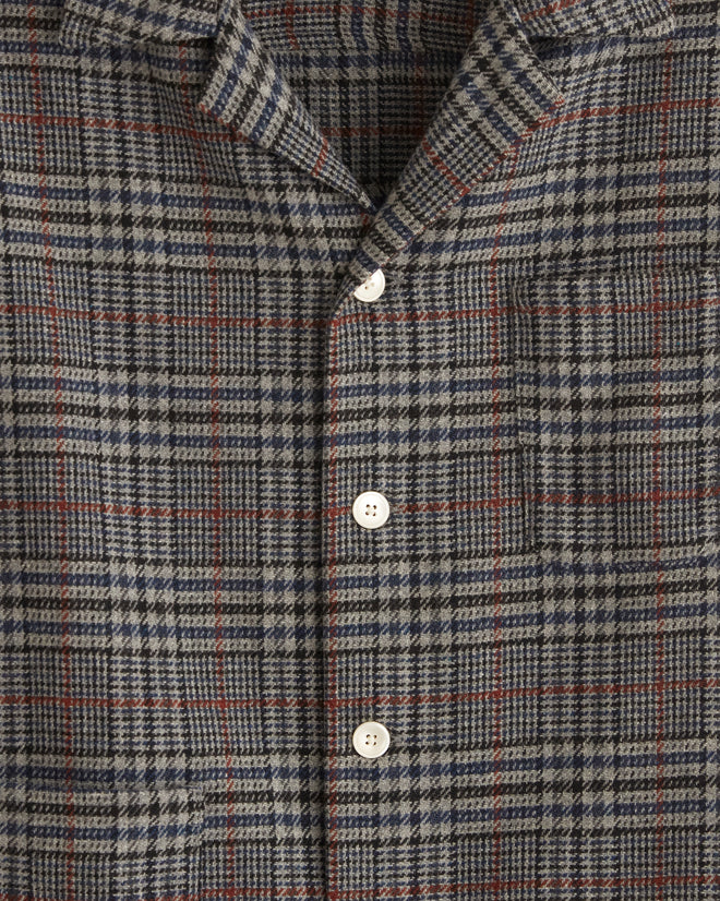 The unique Naval Glen Plaid Long Sleeve Shirt, crafted from 1960s suiting fabric, hangs elegantly against a tiled wall.