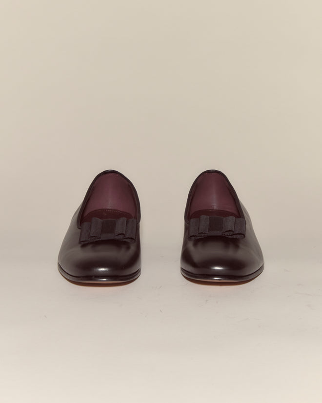 A pair of Opera Pumps in dark burgundy Napa leather with black bows, shown on a plain light background.