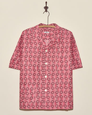 Organic Geometry Shirt (XL/XXL), a short-sleeved, red and white patterned vintage shirt, hangs on a hanger against a beige wall.
