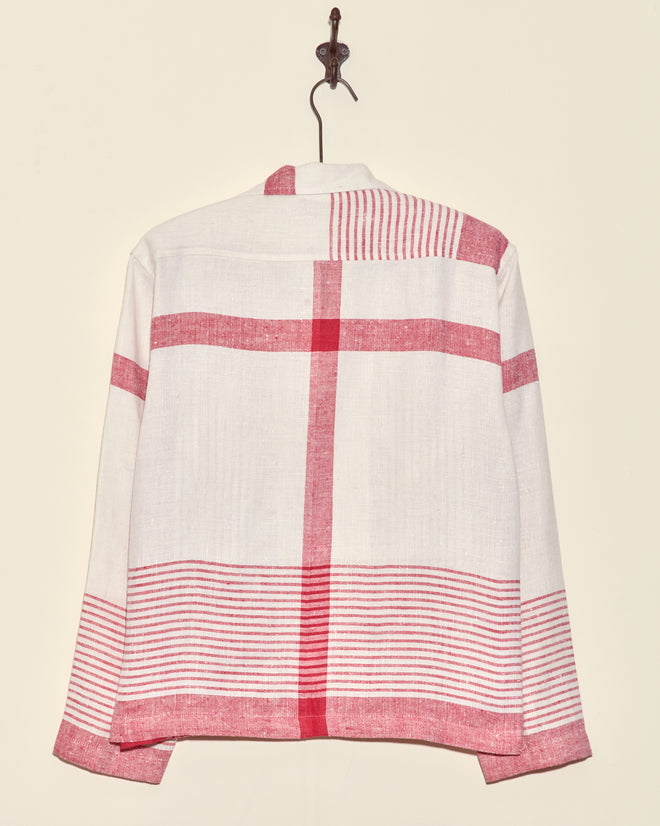 Park Stripe Long Sleeve Shirt - S: White long-sleeve shirt with red stripes and cross pattern inspired by redwork embroidery, displayed on a hook against a beige wall—a unique piece.