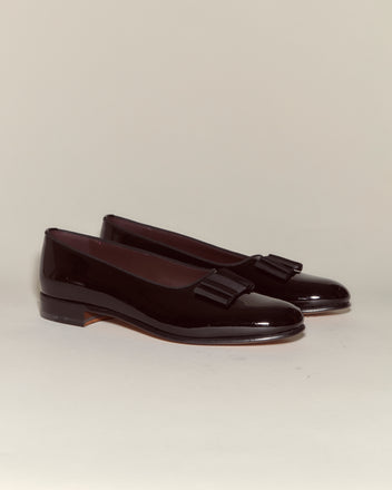 The Patent Opera Pumps are men's evening shoes in black patent leather with low heels and decorative tassels, styled as classic opera pumps on a neutral background.