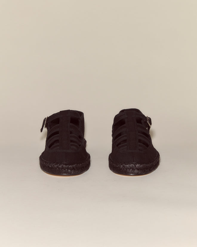 The Peggy Espadrilles - Black are closed-toe summer shoes with woven straps and a classic jute sole, shown from the front against a plain background.