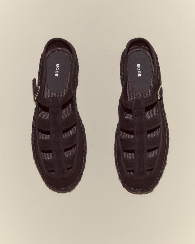 The Peggy Espadrilles - Black, featuring woven texture and buckles, are shown from above on a plain light background—ideal for relaxed summer days.