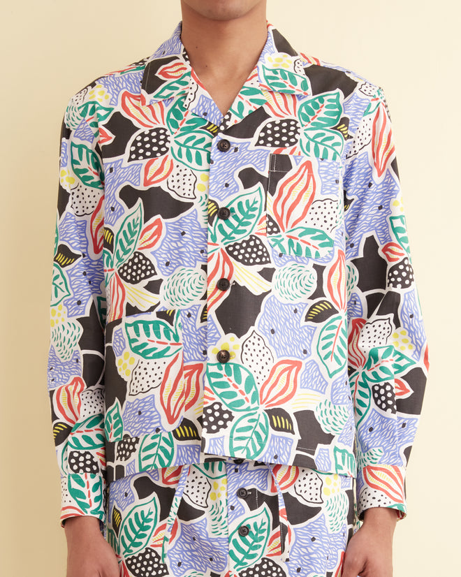 Person wearing the Plantain Jazz Long Sleeve Shirt, a unique oversized button-up featuring a botanical pattern with leaves and abstract shapes, paired with matching pants.