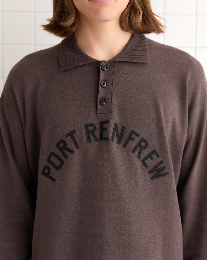 A person wearing the Port Polo in brown/black with "Port Renfrew" elegantly printed on the front.