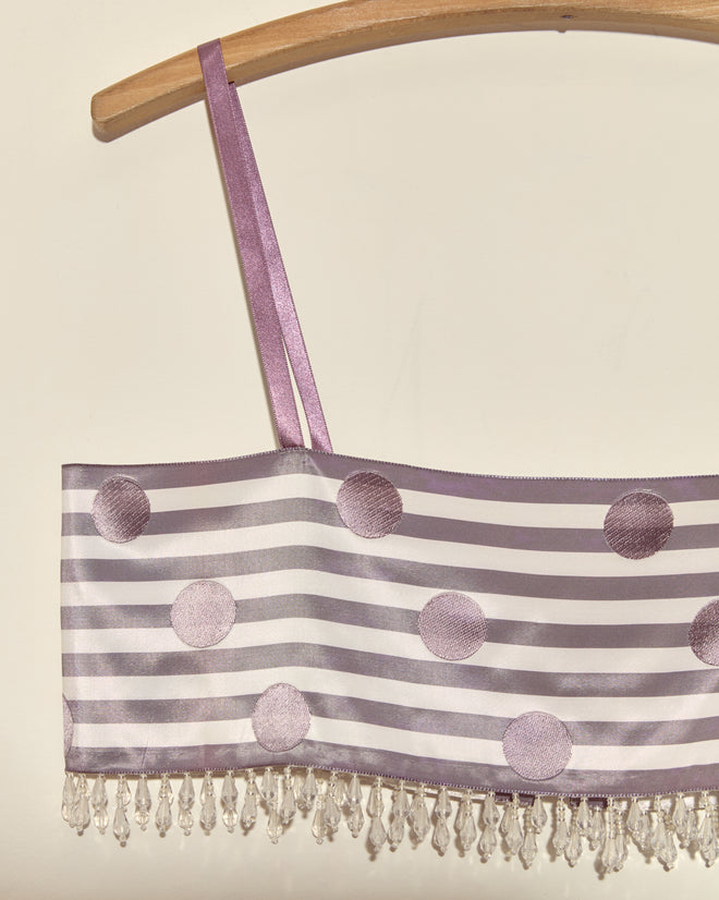 The Purple Note Bra - S features purple and silver stripes with polka dots and beaded fringe, made from deadstock ribbon bra top material by a French couture supplier, shown hanging on a wooden hanger.