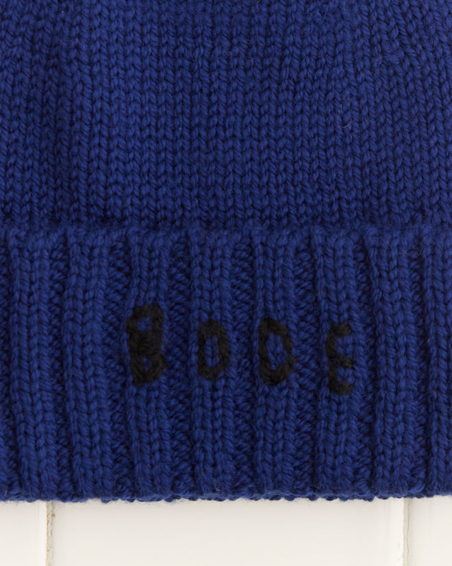 A navy Roll-Up Tassel Beanie with sleek black 