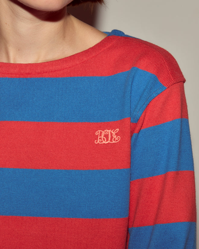 Person wearing the Clubhouse Long Sleeve, featuring red and blue stripes, made from 100% cotton, and finished with a small white embroidered Bode monogram on the chest.