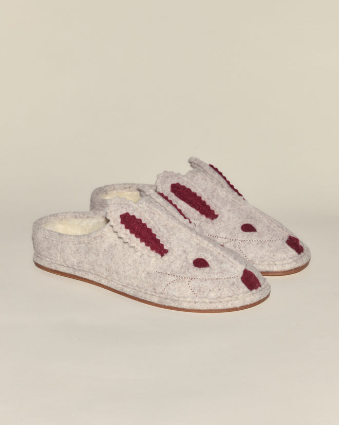 The Rabbit Slipper is a gray, fleece-lined slipper designed to look like a bunny, featuring maroon ears, eyes, and nose on a plain background.