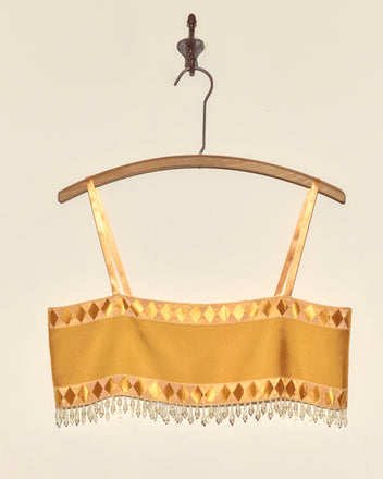 Saffron Pierrot Bra - S featuring diamond patterns, beaded fringe, and Staron jacquard ribbon accents, displayed on a wooden hanger.