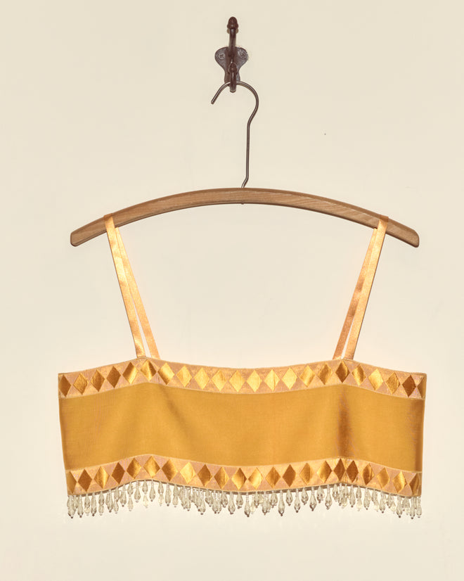 Saffron Pierrot Bra - S featuring diamond patterns, beaded fringe, and Staron jacquard ribbon accents, displayed on a wooden hanger.