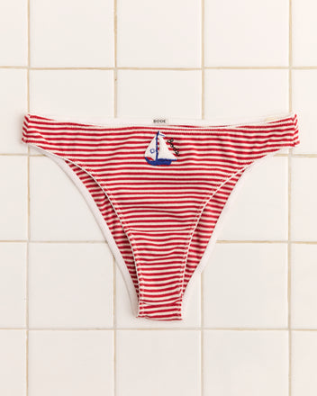 Sailboat Briefs: red and white striped high-cut briefs featuring an appliquéd sailboat patch, shown on a tiled background.