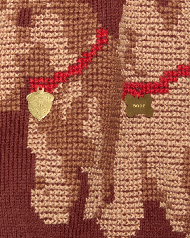 Close-up of the Scottie Pullover wool sweater featuring Scottie dogs with red collars and gold dog tag charms engraved "BODE" and "CHRISTIAN.