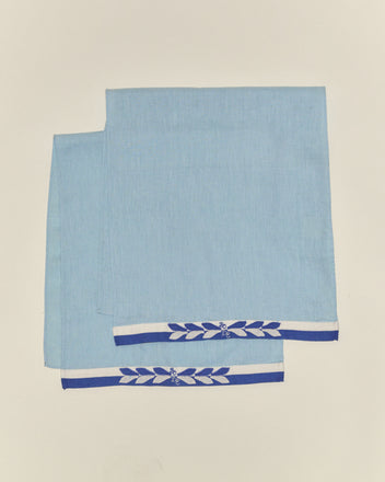 The Seedling Stripe Dish Towels, in light blue with blue and white borders and a delicate floral design, bring the nostalgic charm of midcentury linens to your kitchen.