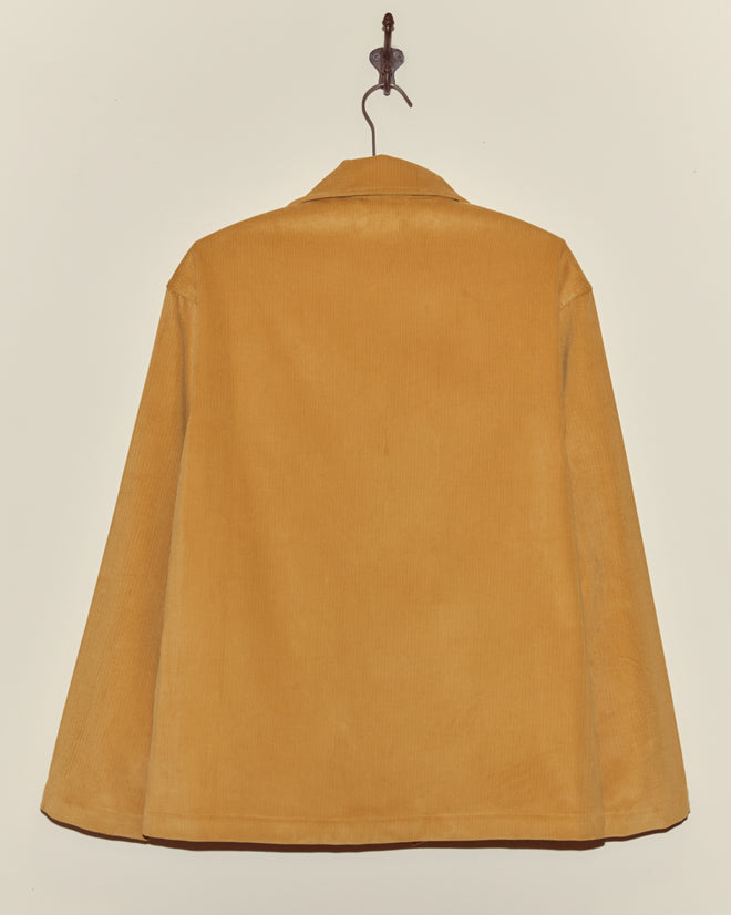 A Custom Senior Cord Front Tab Jacket in mustard yellow corduroy hangs on a hook against a plain light background.