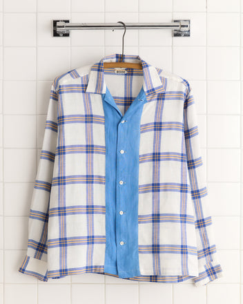 The Skylight Window Long Sleeve Shirt (XS/S) features blue plaid sleeves and collar with a solid light blue front, crafted from vintage bedsheets and displayed on a hanger.