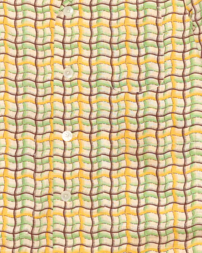 Close-up of the Sorghum Patch Long Sleeve Shirt - XS, a unique deadstock piece with yellow, green, and brown geometric patterns and white buttons.