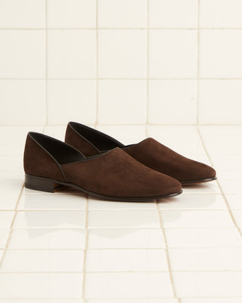 A pair of Suede House Shoes - Brown is elegantly placed on a white tiled floor.