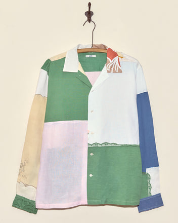 The Sweetpea Napkin Shirt - L/XL is a unique patchwork button-up with green, pink, blue, beige, and white panels—capturing vintage charm in a one-of-a-kind design that looks great hanging on a hook.