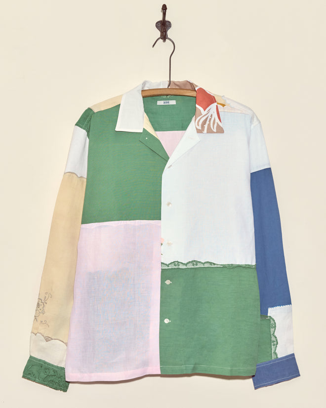 The Sweetpea Napkin Shirt - L/XL is a unique patchwork button-up with green, pink, blue, beige, and white panels—capturing vintage charm in a one-of-a-kind design that looks great hanging on a hook.