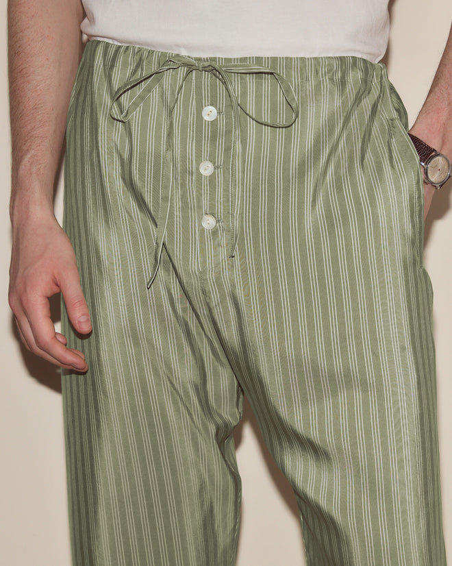 Someone wearing Sylvan Stripe Pajama Pants featuring a green and white stripe pattern and drawstring waist, paired with a white shirt and a watch.