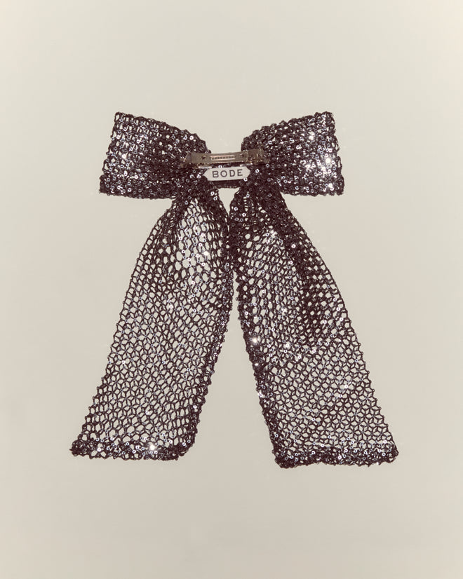 The Tanglenet Bow Barrette is a handmade metallic mesh bow with long tails and a "BODE" label at the center, inspired by 1930s style, shown on a plain background.