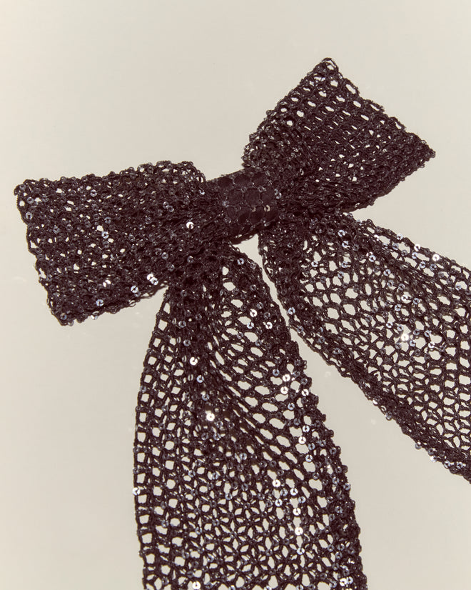 The Tanglenet Bow Barrette features a handmade black mesh bow adorned with silver sequins, neatly tied and styled for an elegant, 1930s-inspired look against a simple light background.