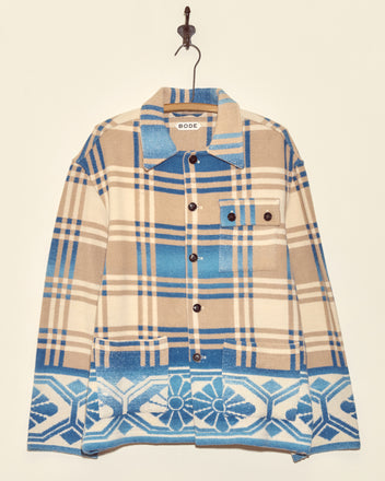 The Tartan Floral Jacket - S/M features unique brown and blue plaid with floral geometric patterns and black buttons, inspired by midcentury wool jacket styles, shown hanging on a hook.
