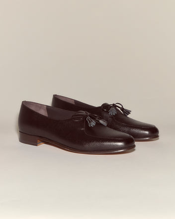 The Tassel Shoes - Brown are vintage loafers crafted from dark brown pebbled leather with tassel accents, shown on a neutral background.