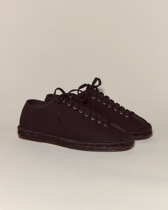 The Tennis Espadrilles - Black are black canvas shoes with matching laces and stitching, featuring a classic design and shown on a plain background.