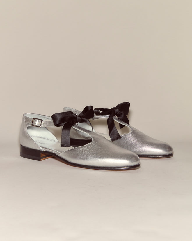 Theater Shoes - Silver: Metallic leather shoes with a chic T-strap design and black ribbon ties, shown against a plain light background.