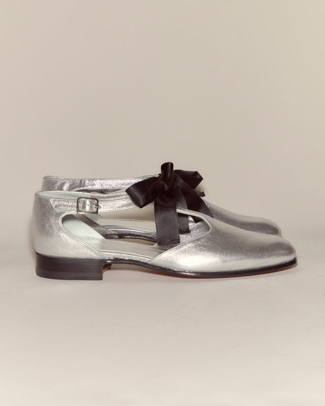Theater Shoes - Silver feature metallic leather, side cutouts, black ribbon laces, and a small buckle for midcentury-inspired elegance, as shown in this stylish side profile.