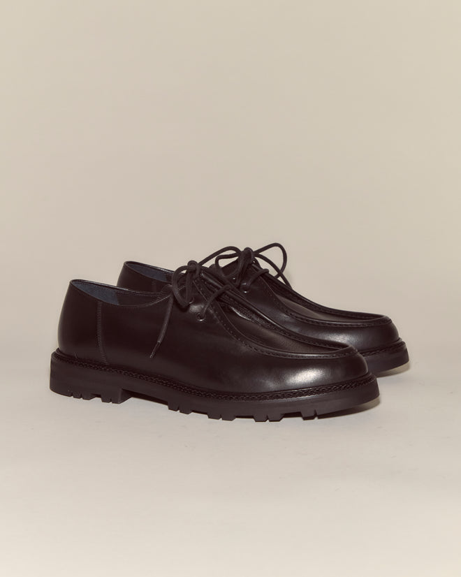 A pair of University Shoes - Black, featuring Napa leather and thick rubber soles, lace-up style, displayed on a light background.