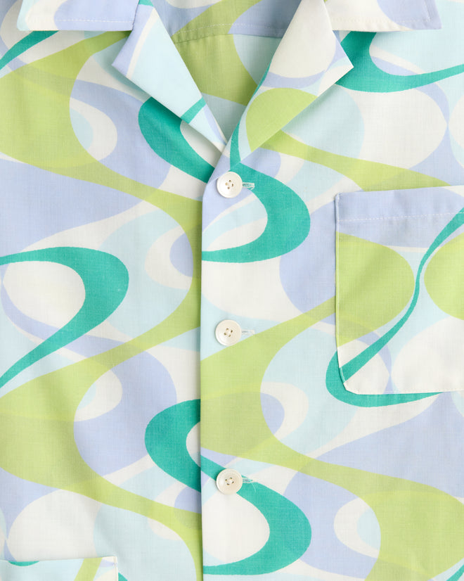 Close-up of the Upstream Creek Shirt, a button-up made from deadstock fabric with a unique abstract pattern in blue, green, and white swirls, plus a front pocket.