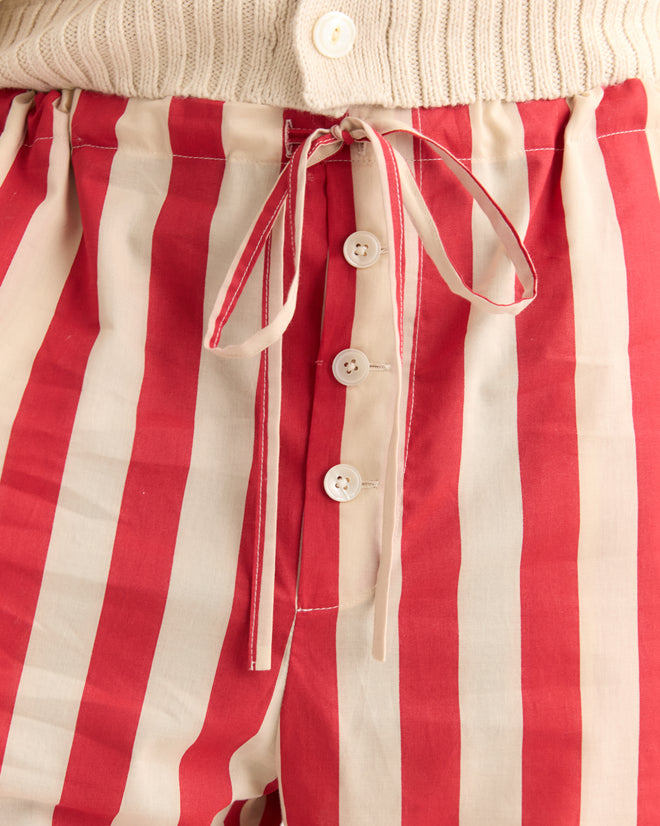 Close-up of Valance Stripe Pajama Pants featuring red and white vertical stripes, a tied drawstring, pearl buttons, and a button fly.