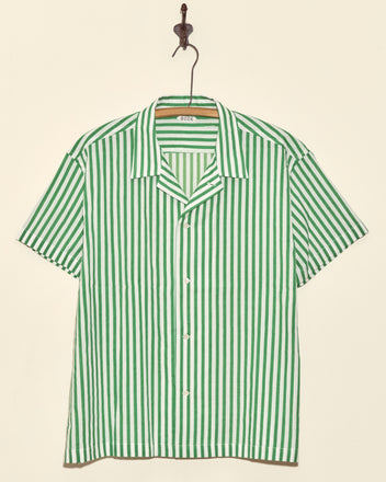 Verdigris Run Short Sleeve Shirt in green and white stripes, displayed on a hook against a beige wall.