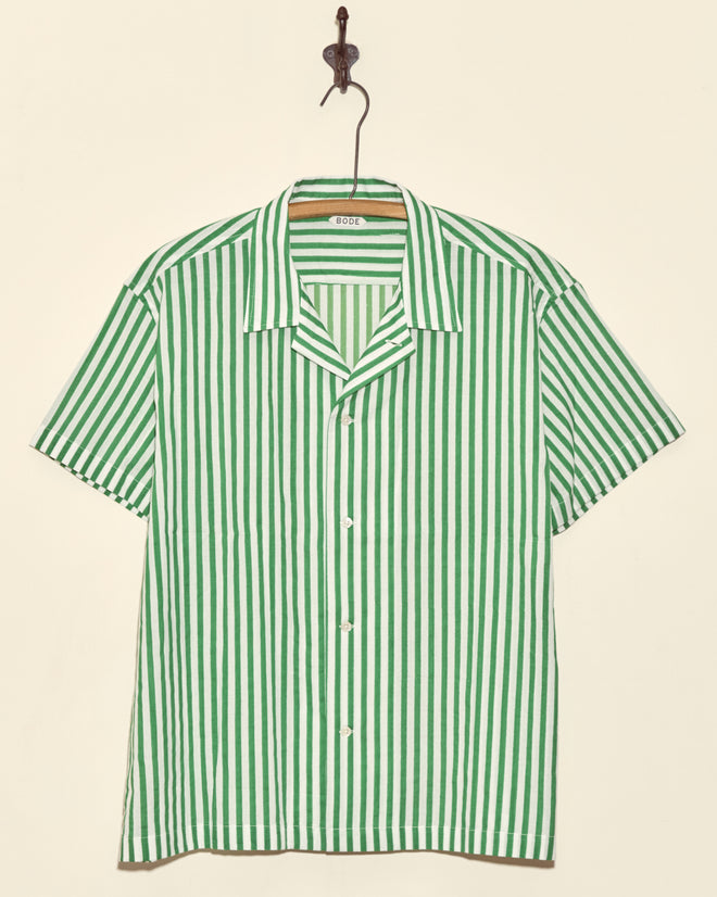 Verdigris Run Short Sleeve Shirt in green and white stripes, displayed on a hook against a beige wall.