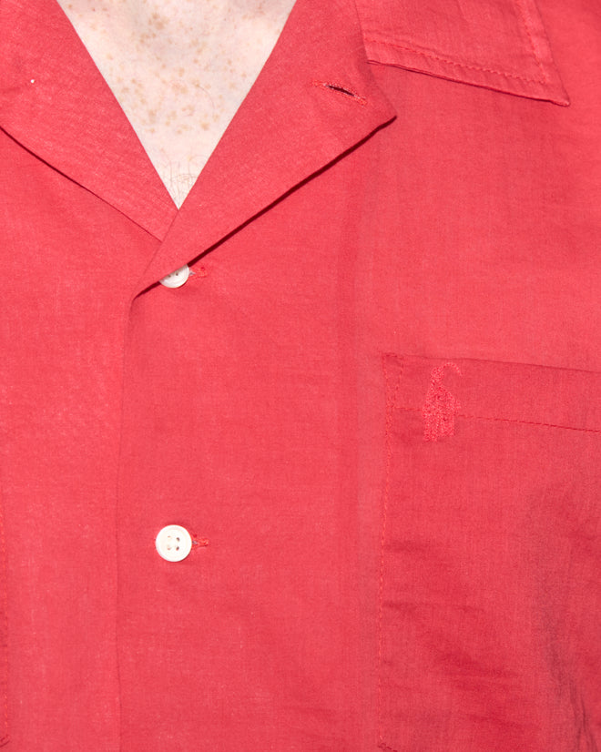 A close-up of the Voile Long Sleeve Shirt - Red, featuring a collar, white buttons, and a boxy silhouette.