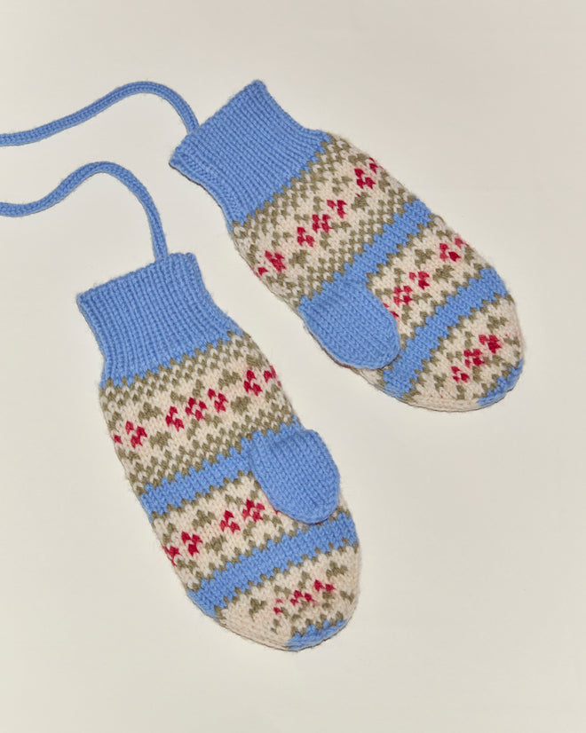 Wedgewood Mittens—blue, beige, and red patterned knit mittens made from virgin wool—are connected by a blue string and shown on a white background.