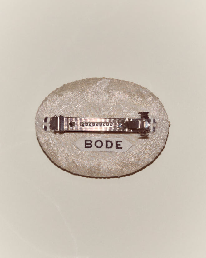The Willow Barrette - White is a fabric oval hair clip with a metal clasp and a 