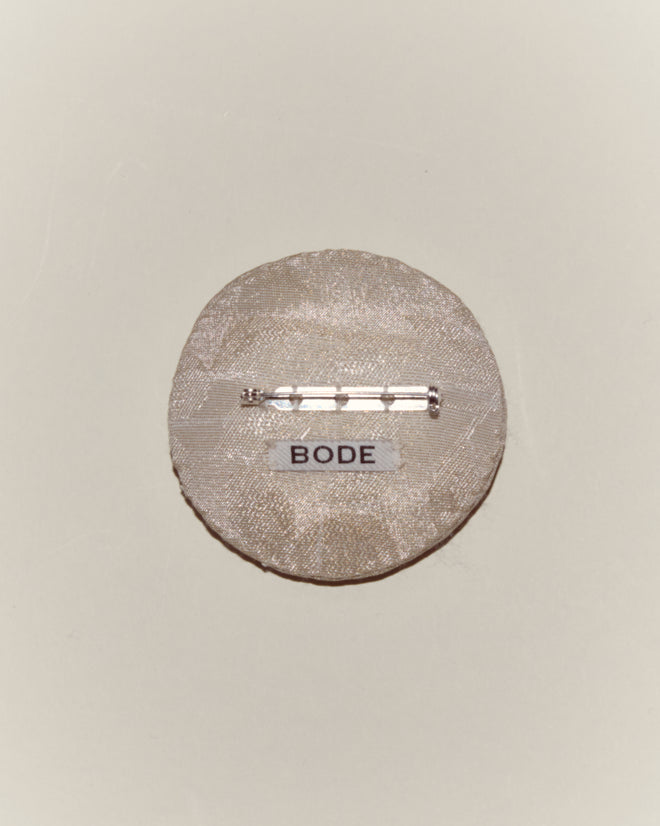 The Willow Brooch - White features a round, textured design with a metal clasp and a "BODE" label on a light background—an elegant piece to enhance your Bode accessories collection.