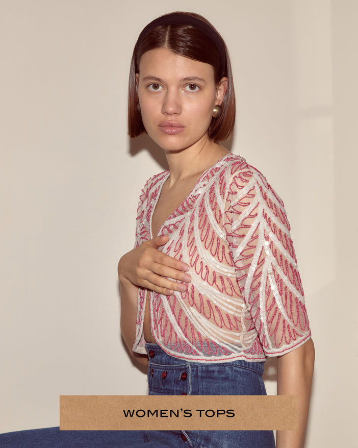 Model wearing a beaded top with rows of pink beads and white sequins.