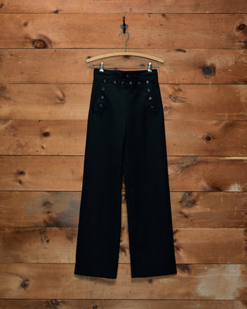 Black Riding Twill Sailor Trousers with two rows of buttons hanging on a wooden hanger.