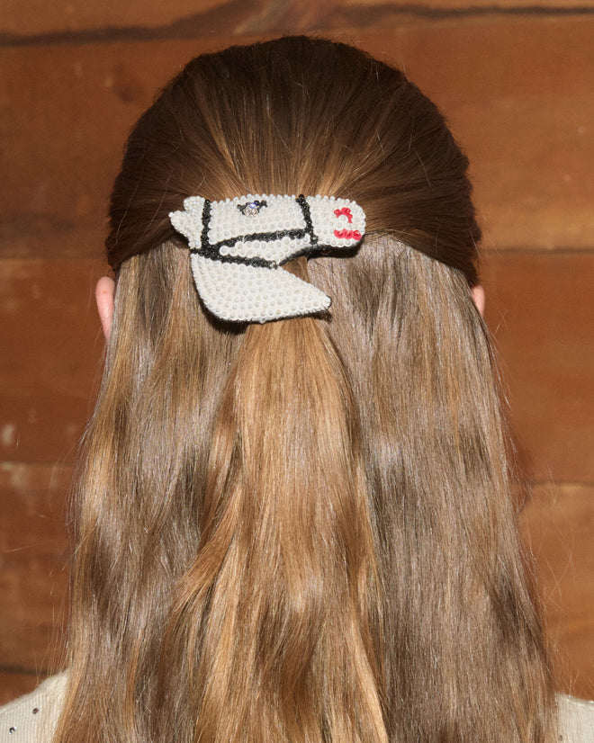 A person with long brown hair wears the Sequin Pony Barrette in Cream, shown from behind.